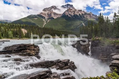 Athabasca Falls with cloudy sky Stock Photos