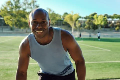 Atheltic man posing for camera, soccer field on background Stock Photos