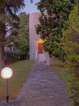 Athens Greece, stone path through the garden to elegant house entrance, night Stock Photos