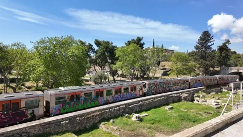 Athens Metro train crossing the frame near Hadrian's Library and acropolis Stock Footage 307173563