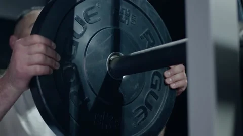 Athlete adding DECATHLON weight plates barbell preparing weightlifting workout 스톡 동영상 155640775