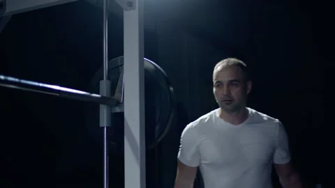 Athlete adding DECATHLON weight plates barbell preparing weightlifting workout Stock Footage 155641173