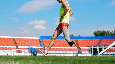 Athlete with an artificial leg is stretching at the stadium Stock Footage 116802745