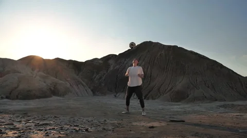 Athlete balances a soccer ball while holding it on his head Stock Footage 133570230