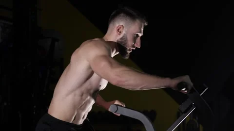 An athlete with a bare torso in the gym doing cycling in the gym. Stock Footage 265079440
