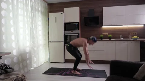 An athlete with a bare torso performs pulling his legs to himself and jumping up Stock Footage 136041682