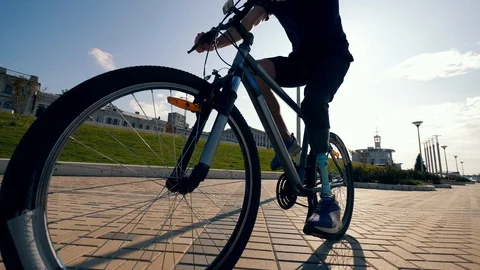 Athlete with a bionic leg is riding a bike along the road Stock Footage 116801631