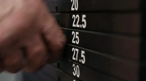 The athlete changes the weight of the load on the trainer Stock Footage 55386749