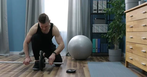 Athlete changing weights on barbell. Man Unscrews Dumbbell to Change its Weig Stock Footage 152835465