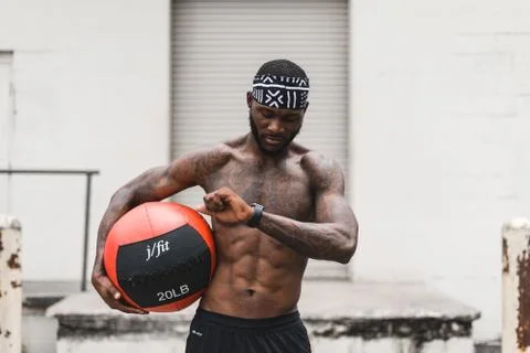 Athlete checking his smart watch and holding a medicine ball Foto stock