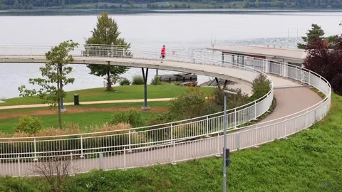 An athlete in colored clothes runs down the bridge up in good weather Vidéo 253827355