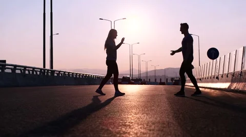 Athlete copuple leaping into the air in triumphant joy in beautiful natural s Stock Footage 66690914