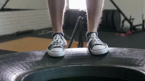 The athlete does heavy training, jumps on a big tire and becomes very resilient. Stock Footage 302983087