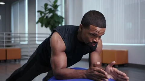 Athlete does plank on gymnastics ball, workingout from home Stock Footage 133536658
