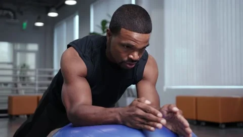 Athlete does plank on gymnastics ball, workingout from home Stock Footage 133536672