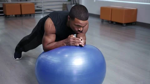 Athlete does plank on gymnastics ball, workingout from home Stock Footage 133536676