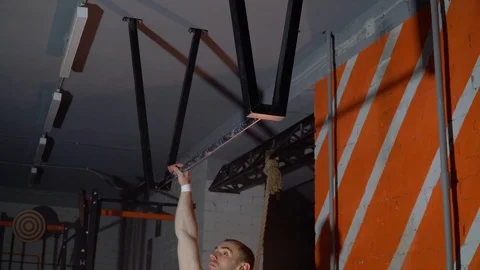 The athlete does pull-ups with a direct grip on a horizontal bar in the gym Stock-Footage 86081009