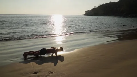 The athlete does push-ups on the beach Video stock 123049470