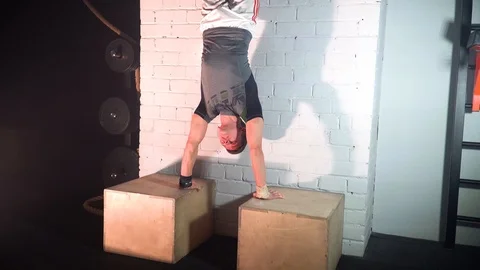 The athlete does push-ups on two cubes leaning against the wall Stock Footage 86080215