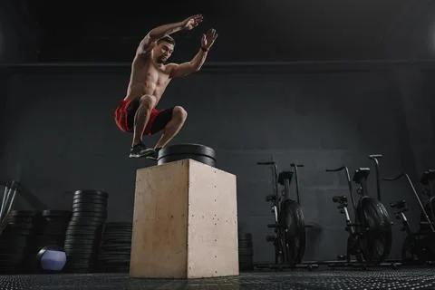 Athlete doing box jump exercise at the crossfit gym Stock Photos