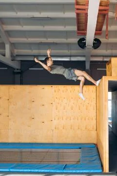 Athlete is doing exercise on the air after pushing off the wooden board Stock Photos