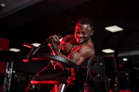 Athlete doing exercise for biceps. African athlete in the gym. Stock Photos