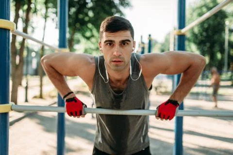 Athlete doing exercise on horizontal bar outdoor Stock-Fotos