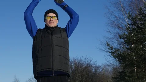 Athlete doing exercise before skiing in the winter forest Stock Footage 86732451