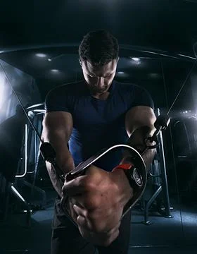 Athlete doing exercises in the gym pulling the tross , closeup, tight t-shirt Stock Photos