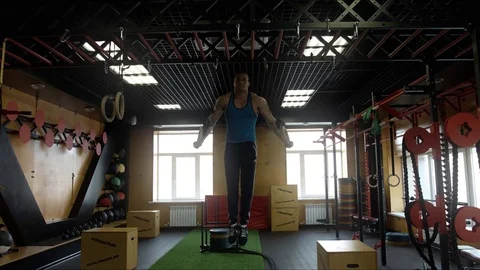 An athlete doing exercises on the rings in the hall of crossfit Stock Footage 75025476