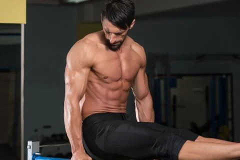 Athlete doing heavy weight exercise on parallel bars Stock Photos