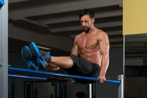 Athlete doing heavy weight exercise on parallel bars Stock Photos