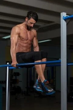 Athlete doing heavy weight exercise on parallel bars Stock Photos