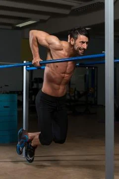 Athlete doing heavy weight exercise on parallel bars 스톡 사진