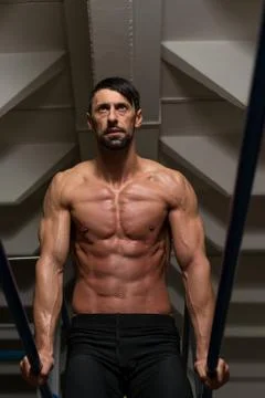 Athlete doing heavy weight exercise on parallel bars Stock Photos