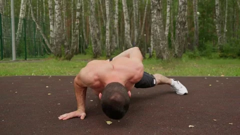 Athlete doing one-arm pushups in park 스톡 동영상 330921381