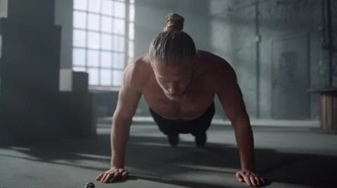 Athlete doing press ups during workout. Man making functional training in gym 库存照片