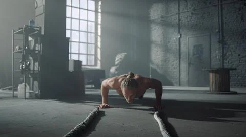 Athlete doing press ups during workout. Man making functional training in gym 写真素材