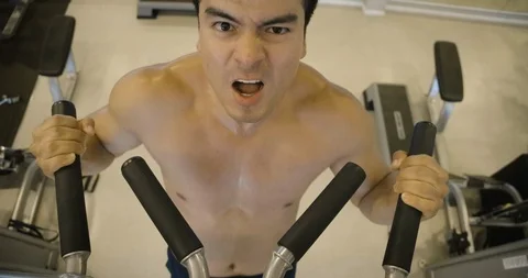 Athlete doing pull-up on horizontal bar in the gym. Видео 102975204