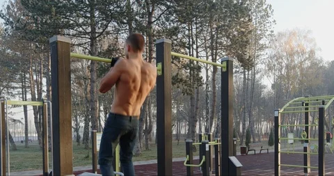 Athlete doing pull ups in the park Stock Footage 121715265