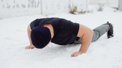Athlete doing push ups on the snow, crossfit exercise Stock Footage 99934863