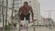 Athlete Doing Pushups On Bars At The Beach Stock Footage