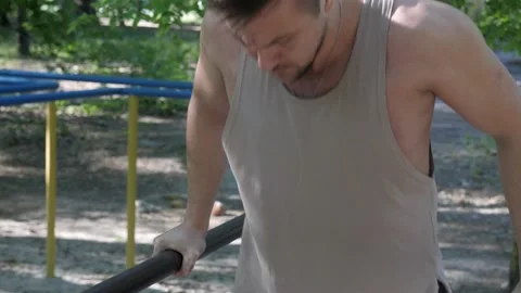 An athlete doing pushups on a bars Stock Footage 130268592