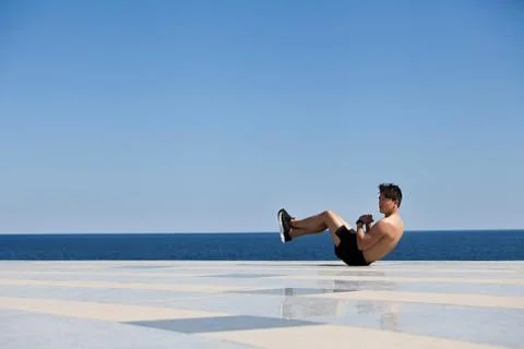 Athlete doing sit-ups on tiled surface Stock Photos
