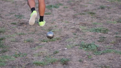Athlete dragging a hammer on the grass for throwing training Stock Footage 344994268