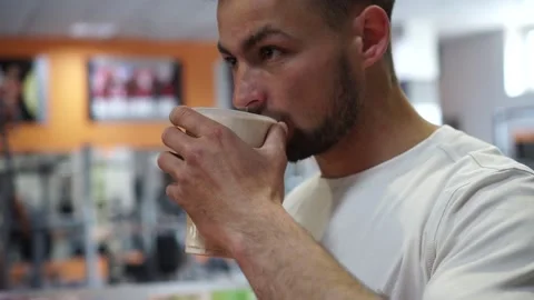 An athlete drinks a mixture of protein after a workout in the gym Video stock 132172727