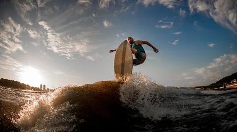 Athlete effectively jumping over the wave on the wakeboarding board 스톡 사진