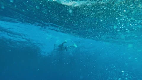 Athlete Executing Duck Dive Surrounded By Bubbles And Sunlight Filtering Through Stock Footage 324056798