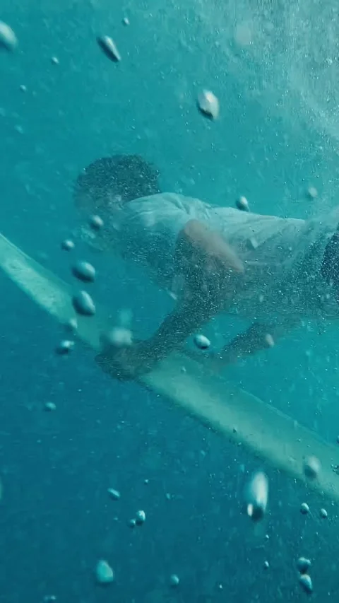 Athlete Executing Duck Dive Surrounded By Bubbles And Sunlight Filtering Through Stock Footage 327094834