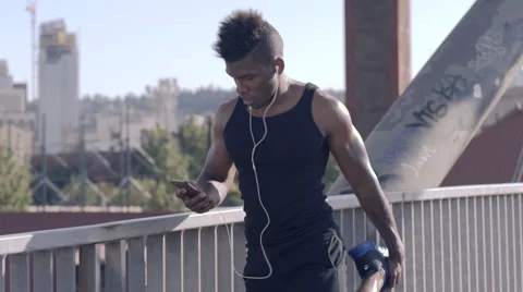 Athlete Flips Through Playlist On His Phone, Stretches Before His Work Out (4K) Stock Footage 51475984